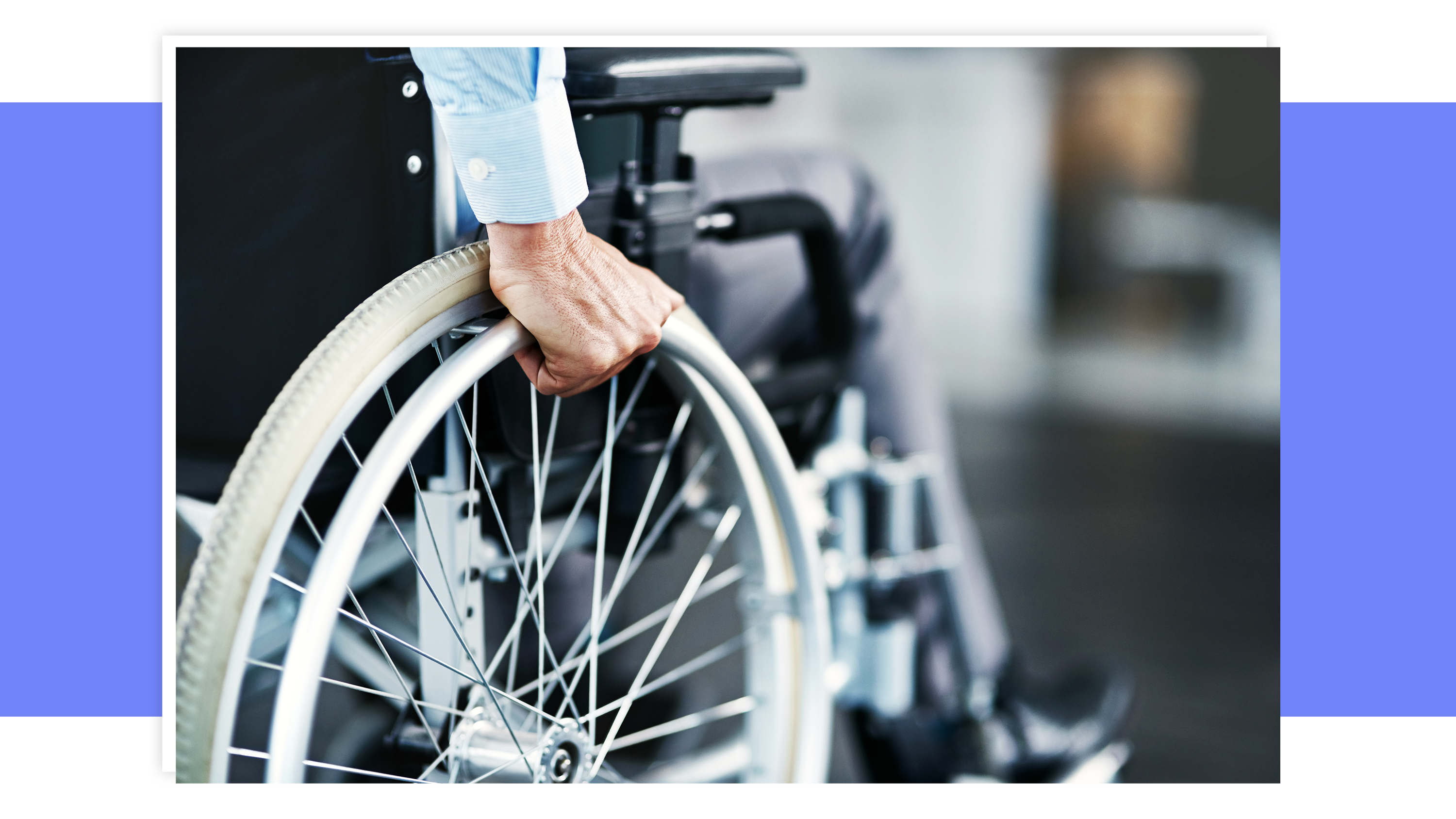 Person with limited mobility using hands to push wheelchair around outdoors.