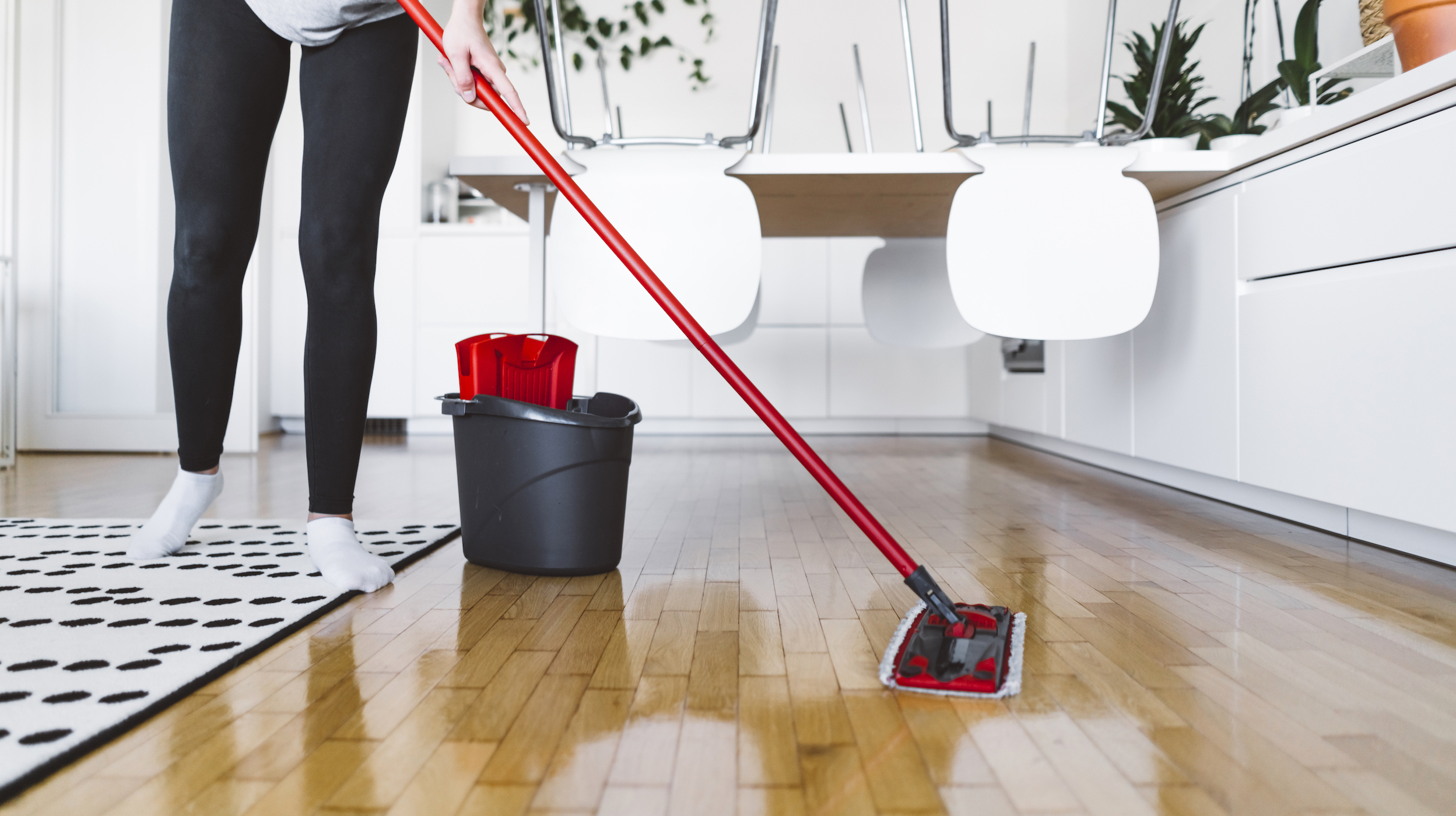 Woman cleaning the wood floors in her home.