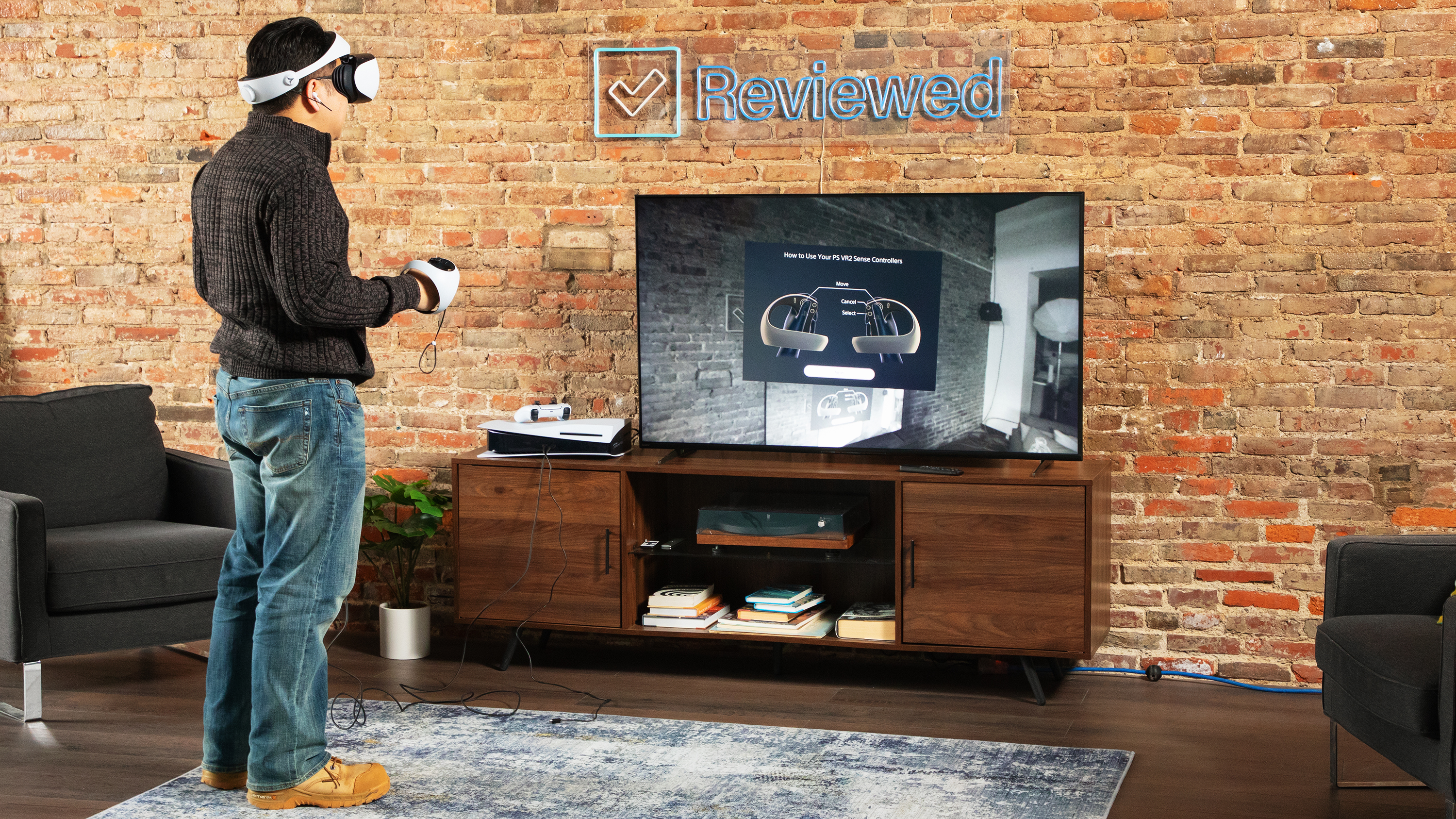 PSVR 2 kulaklık kullanarak düz ekran TV'ye bakan bir kişi