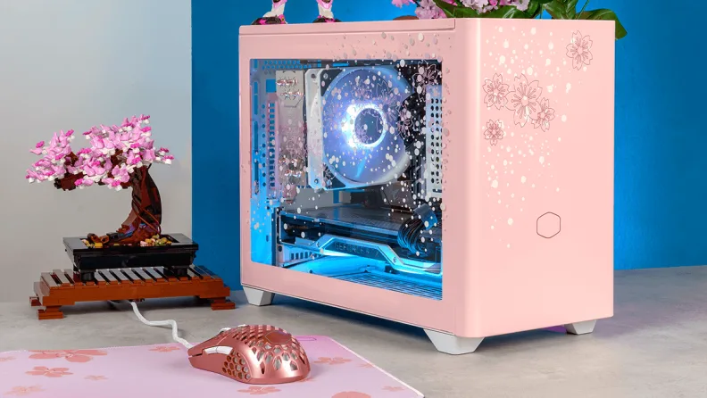 Malý růžový počítač na stole s růžovým bonsai