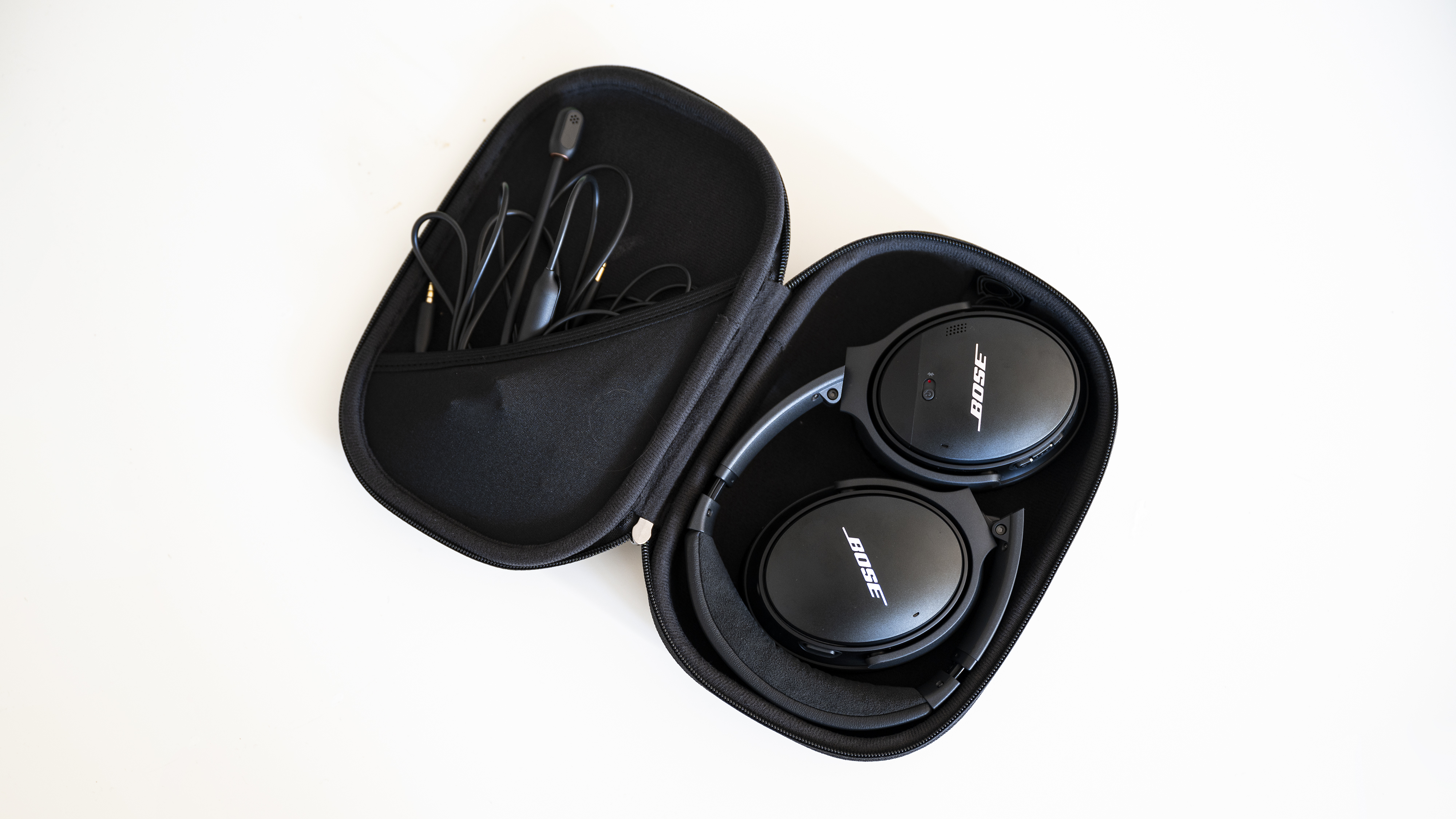 A pair of headphones and wires tucked neatly into a protective case.