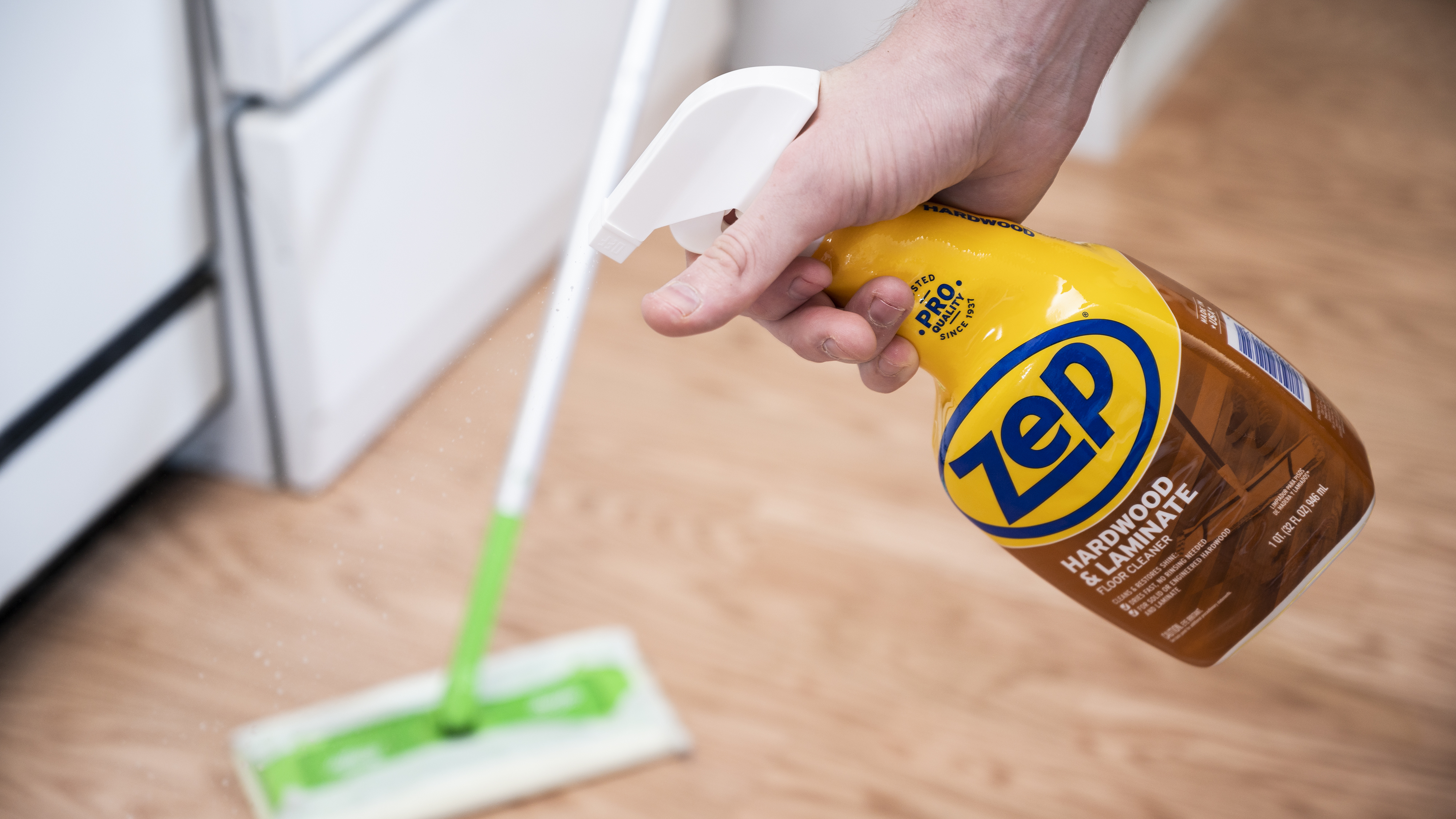 a person sprays Zep hardwood floor cleaner on a floor