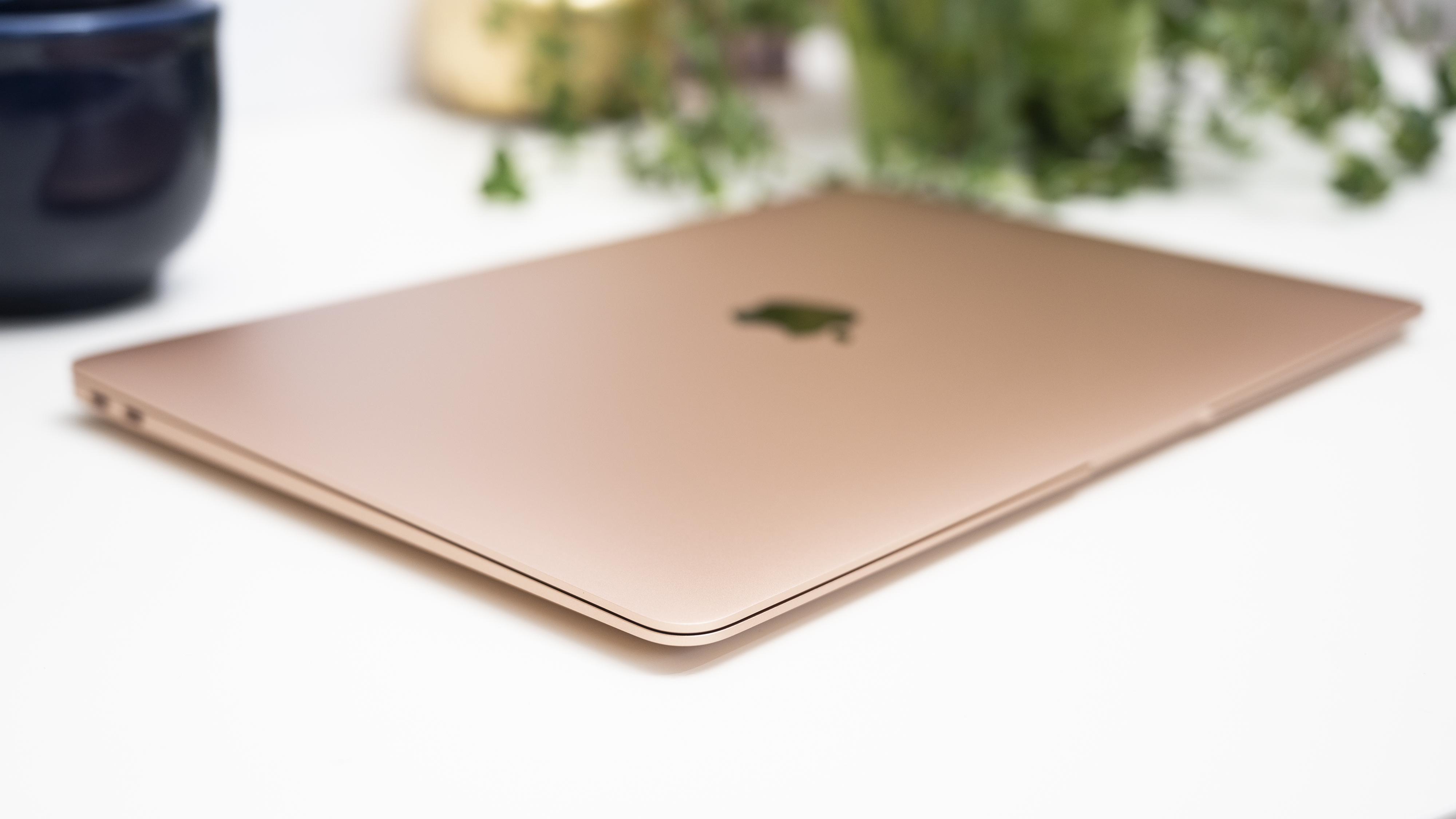 Un MacBook Air M1 di rosa-oro si trova chiuso su una superficie bianca